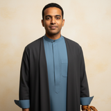 Sami Rahim, a South Asian man, smiles in a sophisticated editorial portrait against a warm cream backdrop, embodying modern m